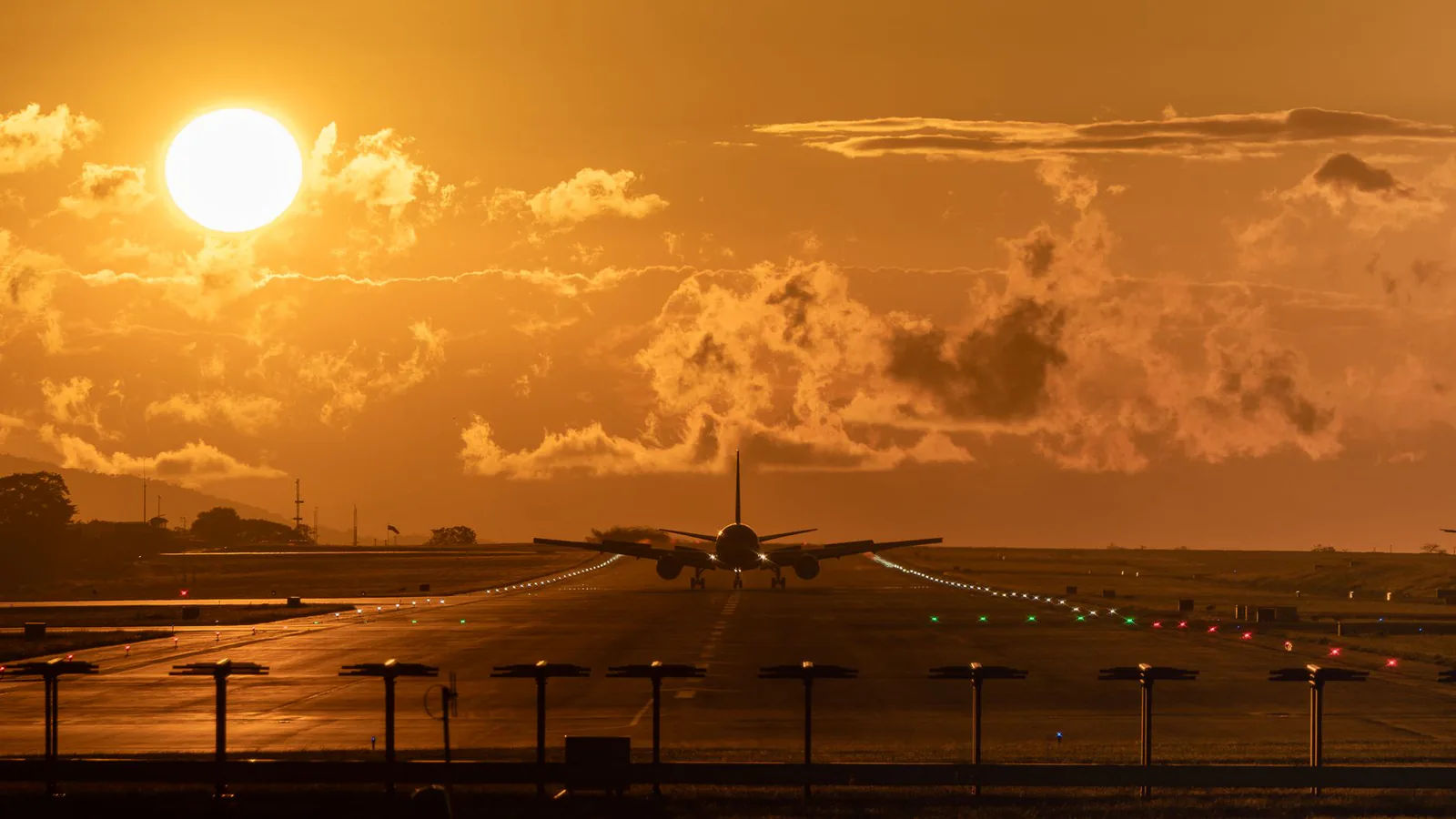 Airplane on runway at sunset